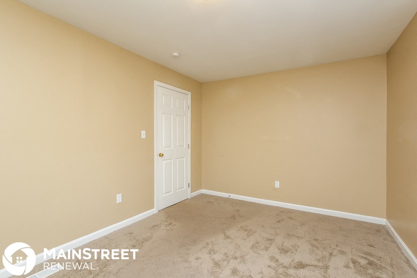 a empty room with a door and a carpeted floor