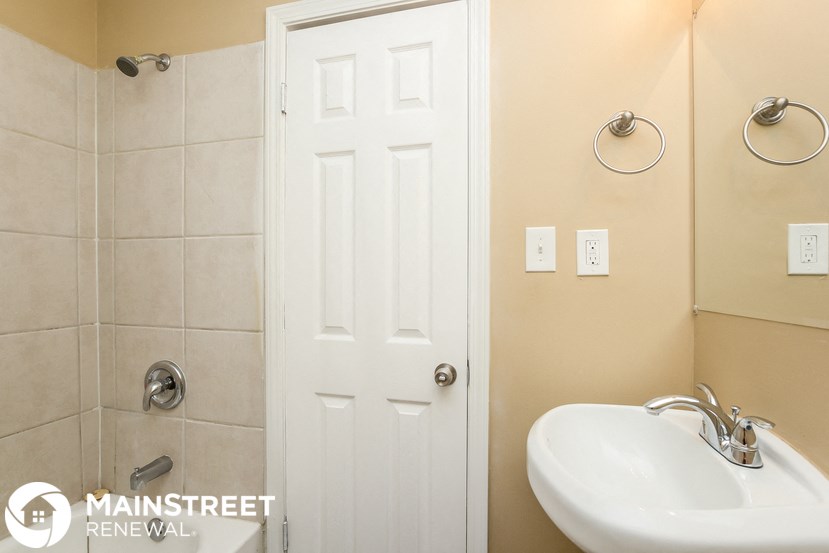 a bathroom with a white sink and a white door