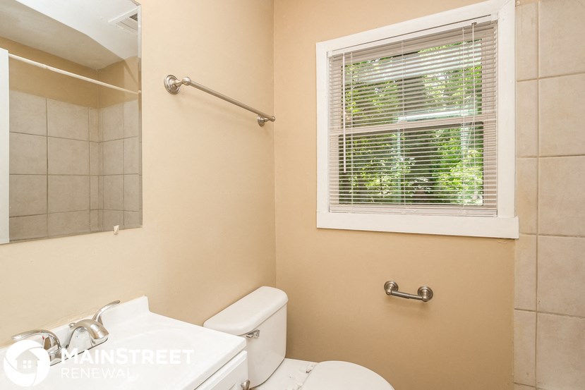 a bathroom with a window and a toilet and a sink