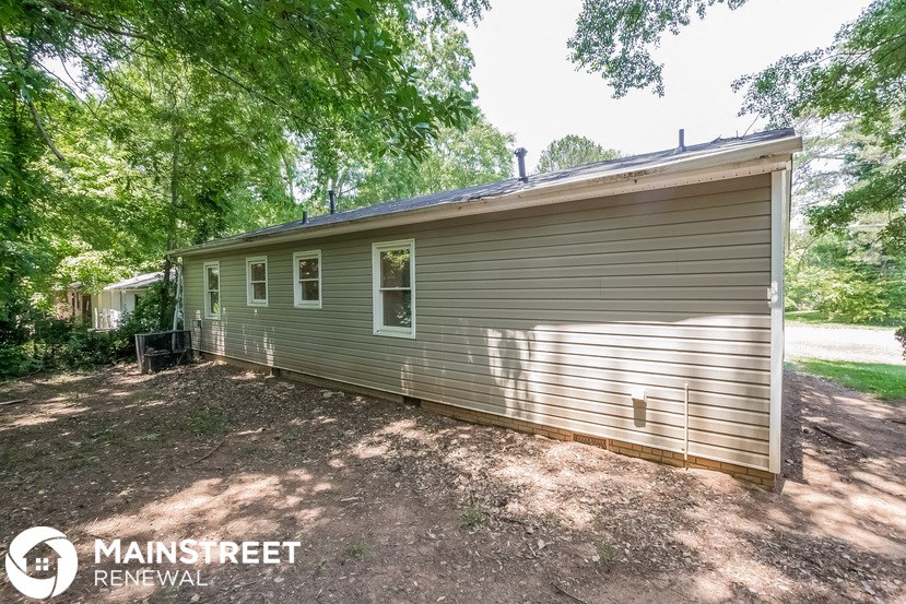 a small house with a garage and some trees