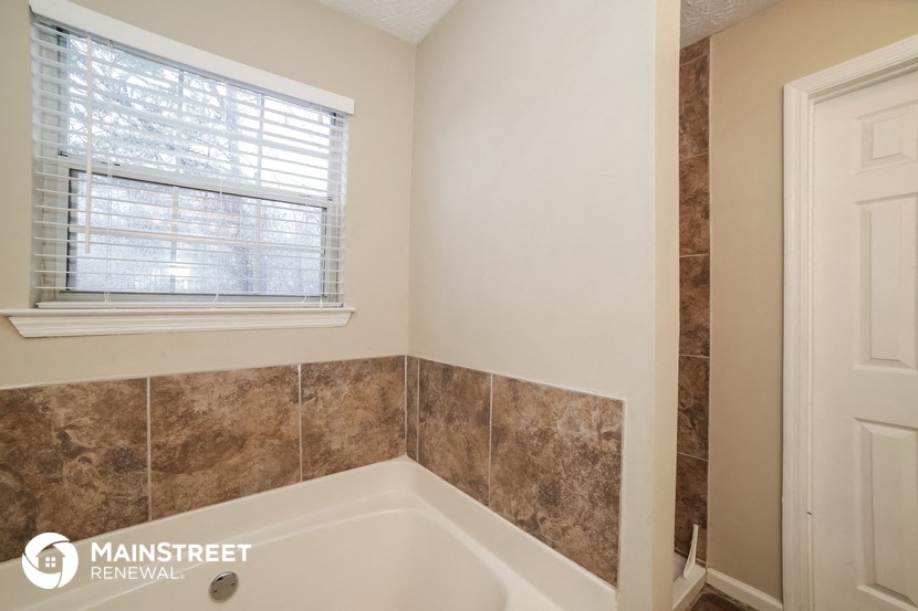 the bathroom has a large tub and a window