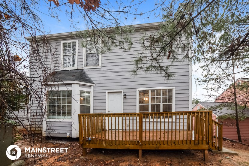 a white house with a wooden deck in front of it