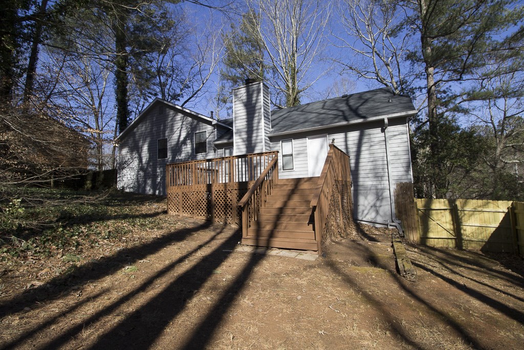 a white house with a wooden deck in front of it