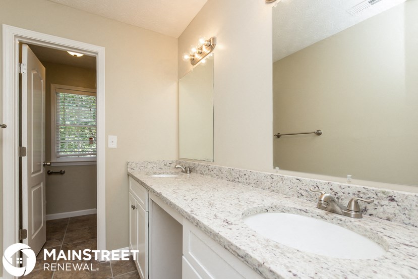 a bathroom with two sinks and a large mirror