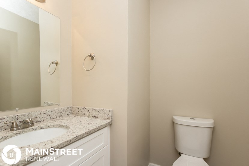 a bathroom with a toilet and a sink and a mirror