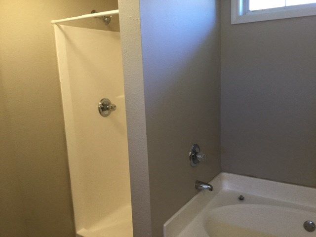 a white bathroom with a shower and a sink
