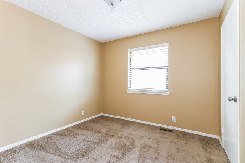an empty room with carpet and a window