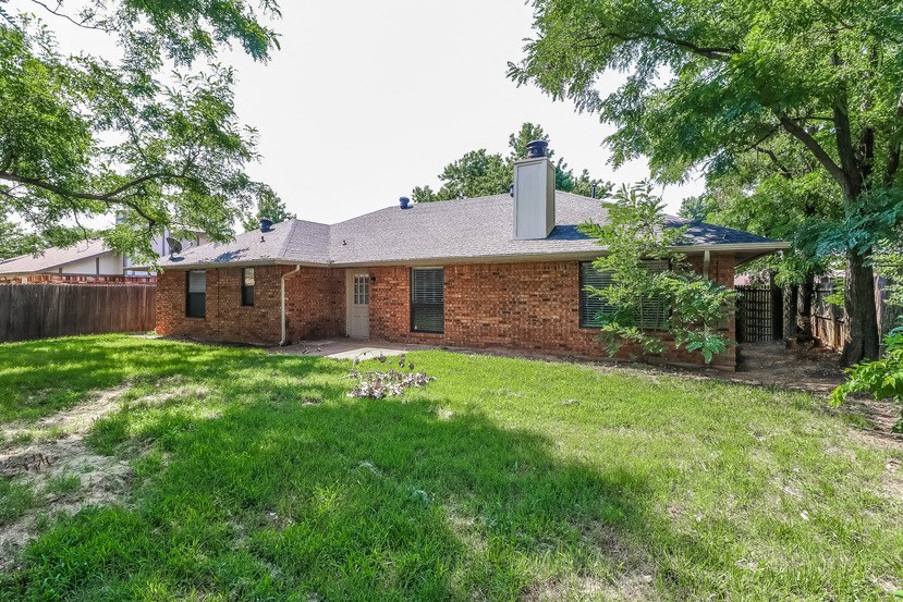 a brick house with a yard and a fence