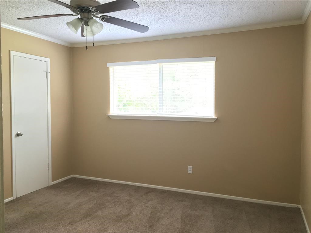 a living room with a ceiling fan and a window
