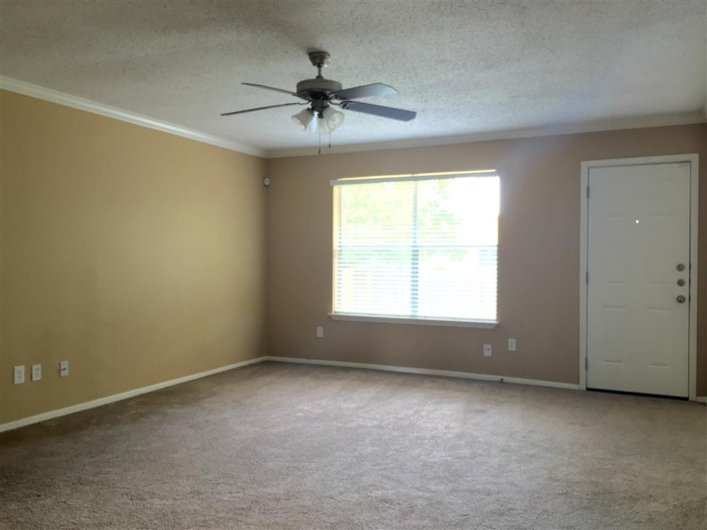 a living room with a ceiling fan and a window