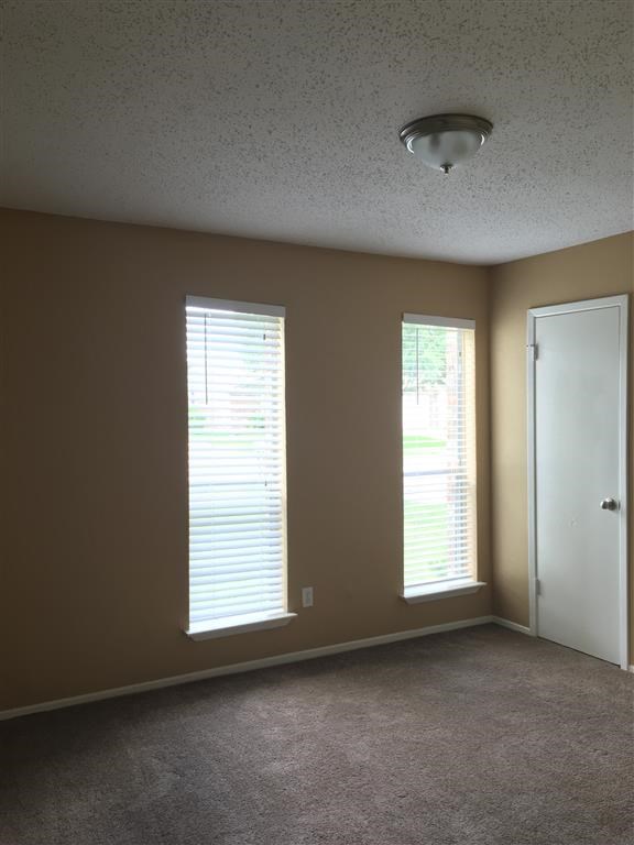 a living room with two windows and a door
