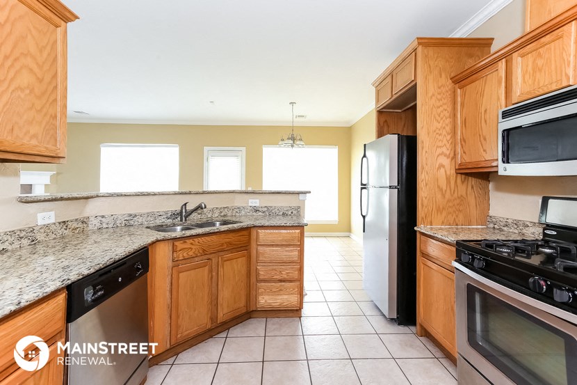 a kitchen with wooden cabinets and stainless steel appliances and granite counter tops