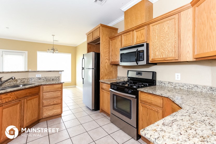a kitchen with wooden cabinets and stainless steel appliances