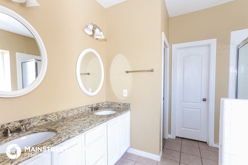 a bathroom with two sinks and two mirrors