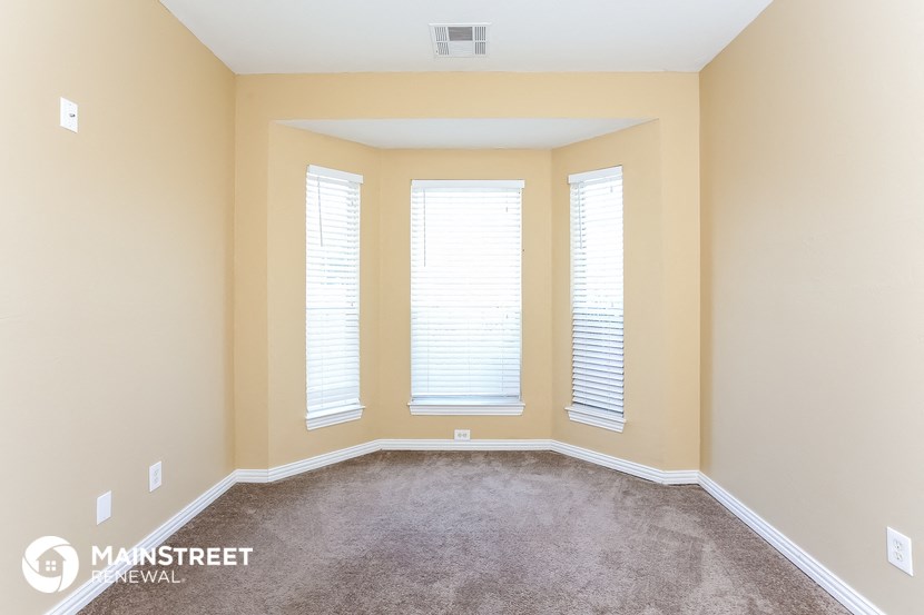 a empty room with three windows and a carpet