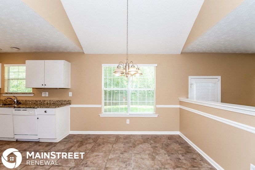 a kitchen with white cabinets and a sink and a window