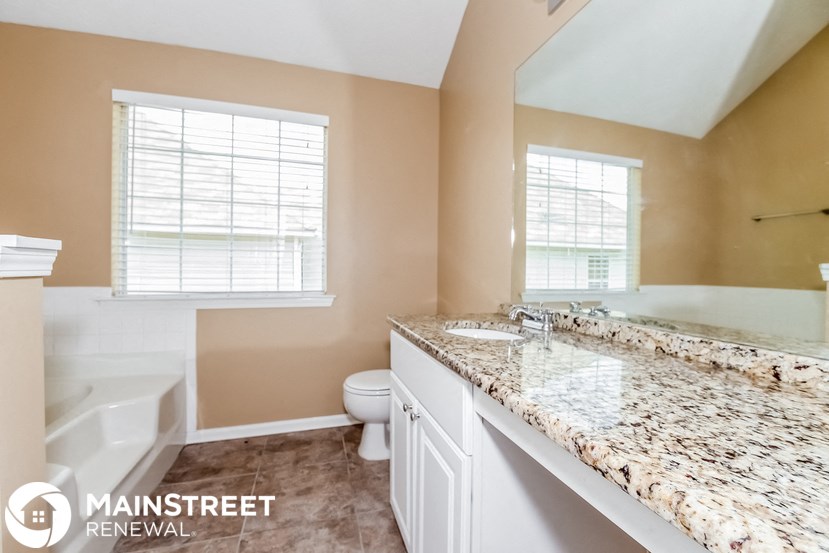 a bathroom with a large mirror and a toilet and a sink
