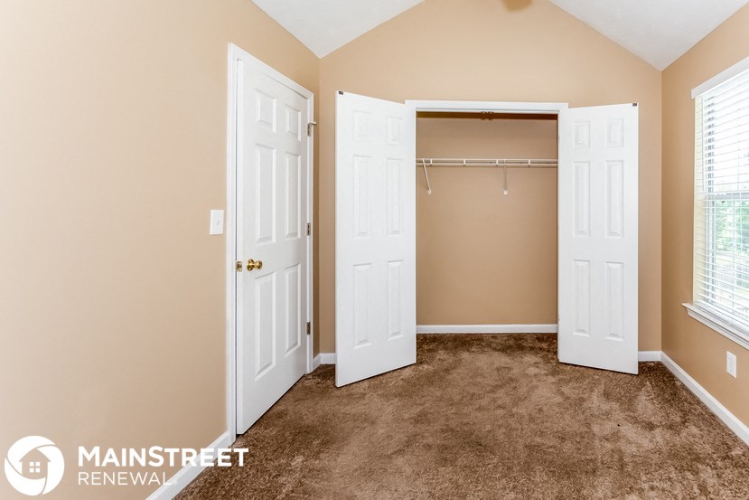a bedroom with two closets and a carpeted floor and two doors
