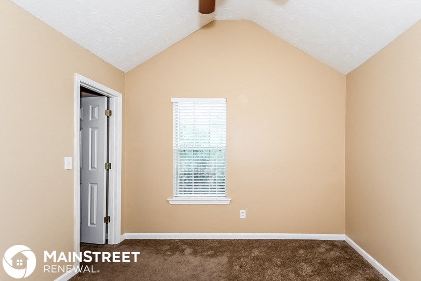 the upstairs bedroom with carpet and a door to the bathroom