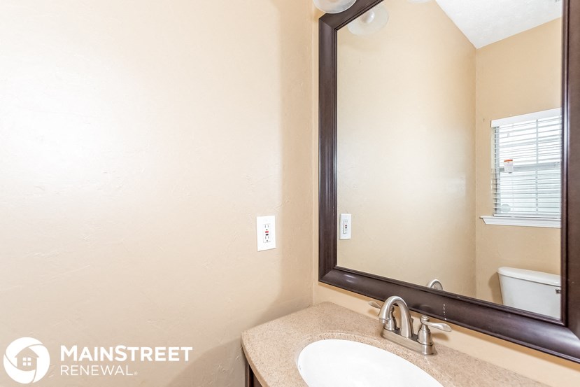 a bathroom with a mirror and a sink and a toilet