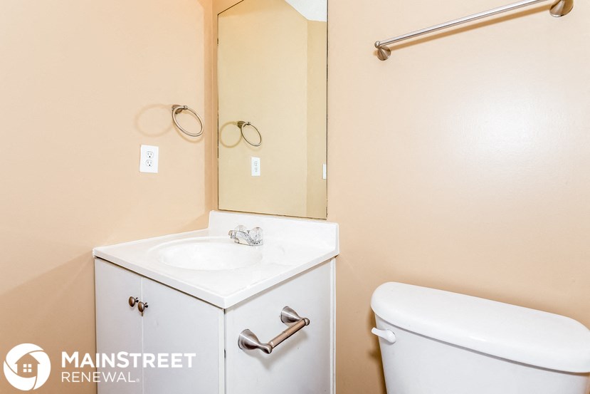 a bathroom with a toilet and a sink and a mirror