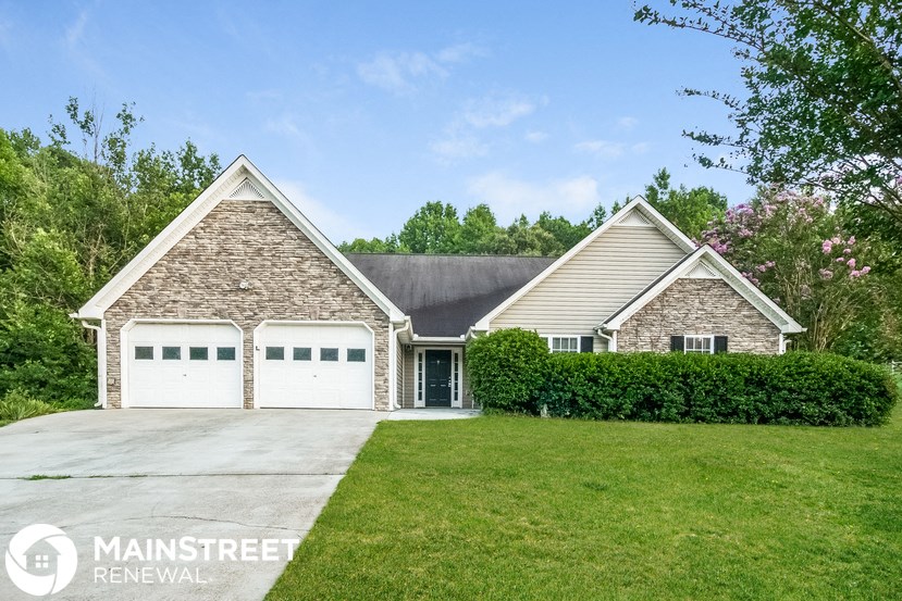 a brick house with a white garage door and a green lawn