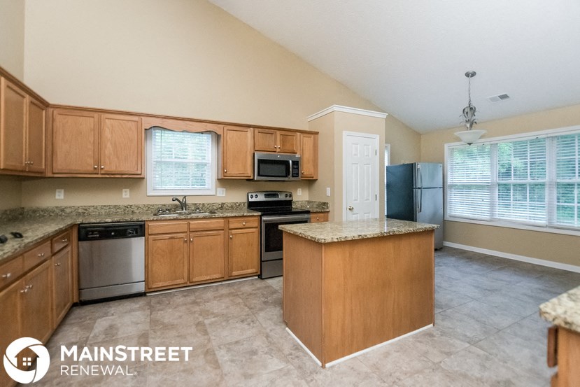 a kitchen with wooden cabinets and stainless steel appliances