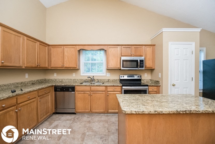 a kitchen with wooden cabinets and granite counter tops