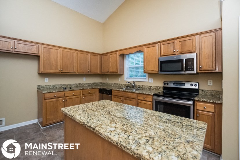 a kitchen with granite counter tops and wooden cabinets
