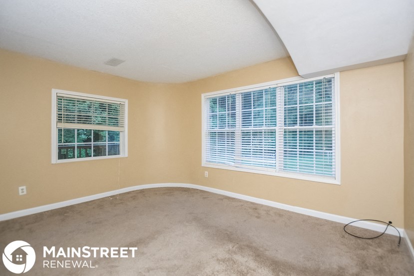 the living room of a home with a carpeted floor and a large window