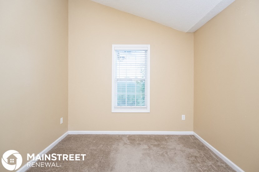 the upstairs bedroom with carpet and a window