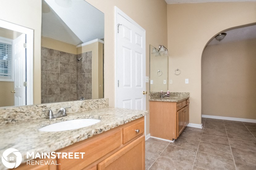 a bathroom with a sink and a shower and a mirror