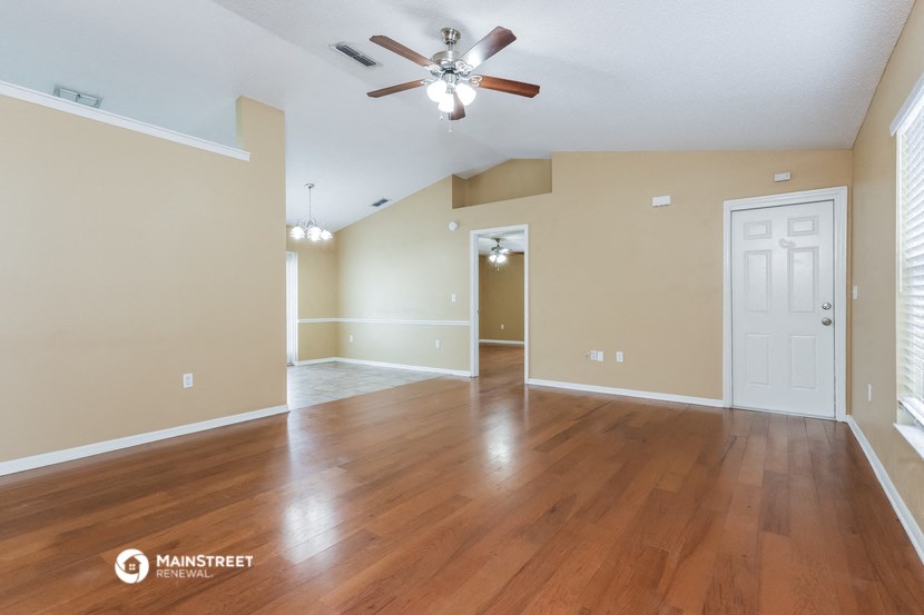 the living room and dining room with hardwood flooring and ceiling fan