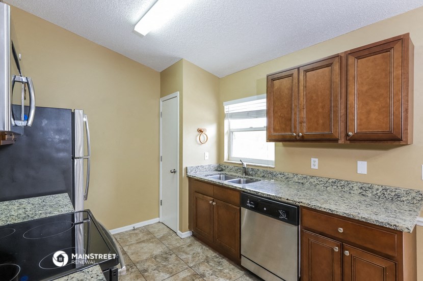 a kitchen with wooden cabinets and a stainless steel refrigerator