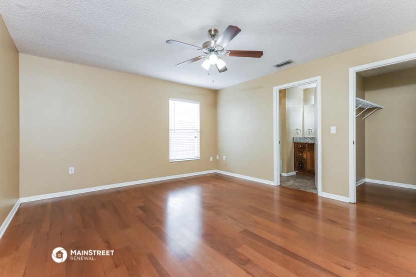 the living room with hardwood floors and a ceiling fan