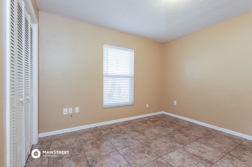 the spacious living room has a large window and tile flooring