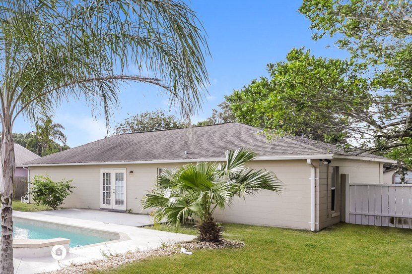 a white house with a pool and a palm tree