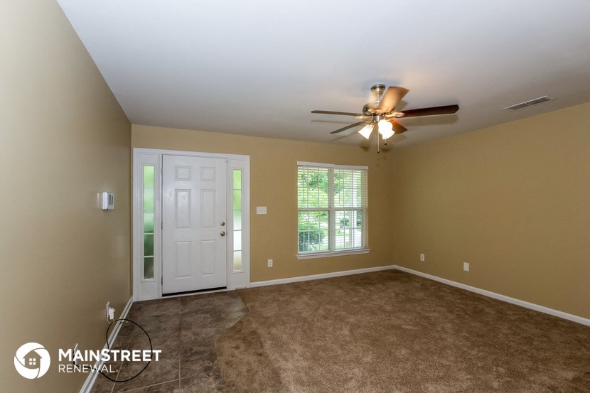 the master bedroom with carpet and a ceiling fan