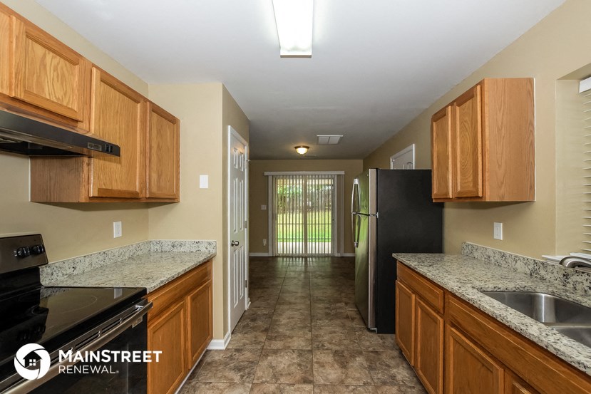 a kitchen with wooden cabinets and a black refrigerator