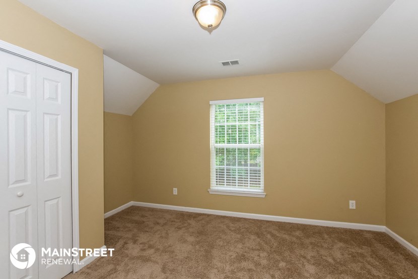 the upstairs bedroom with carpeted flooring and a white door