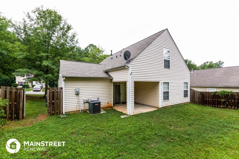 a white house with a yard and a wood fence