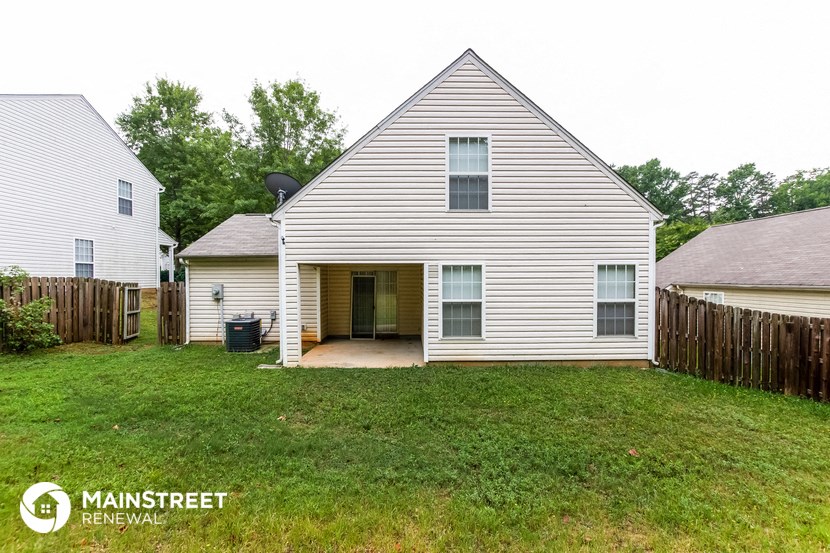 a white house with a yard and a wooden fence