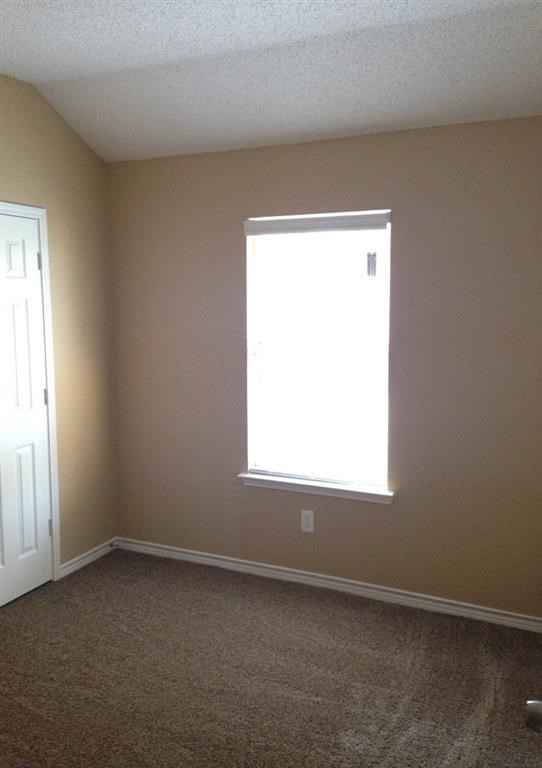 an empty room with a window and a door