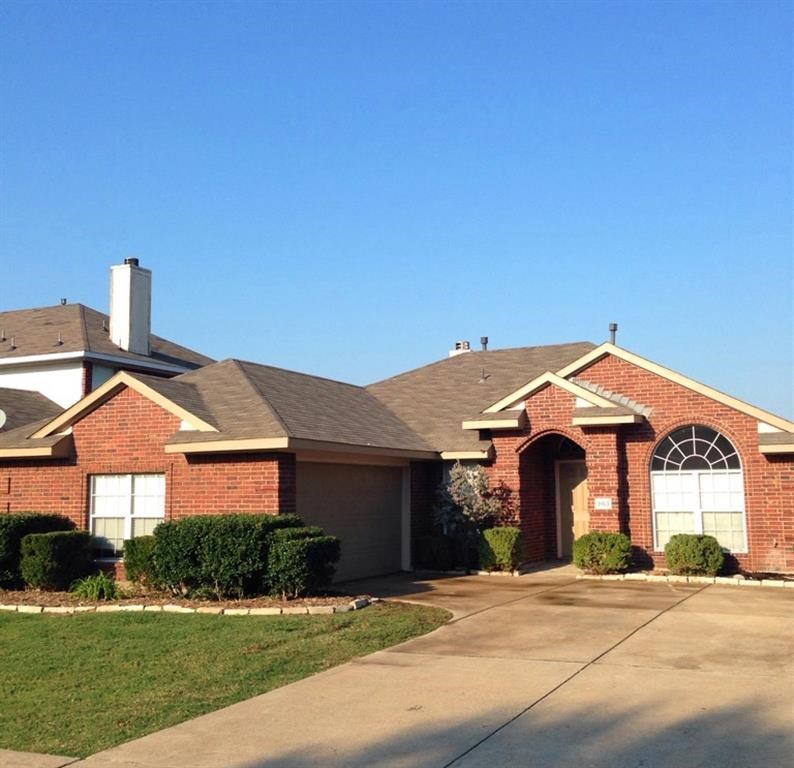 a brick house with a sidewalk in front of it