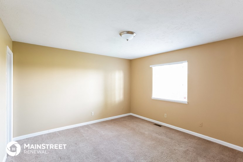 the living room of a house with a carpet and a window