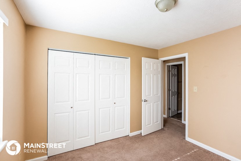 a bedroom with two closets and a door to a hallway