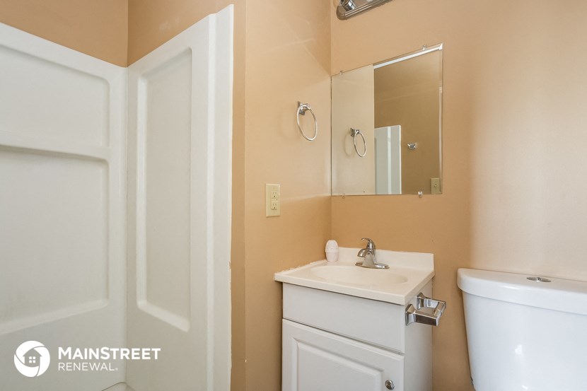 a bathroom with a sink toilet and a mirror