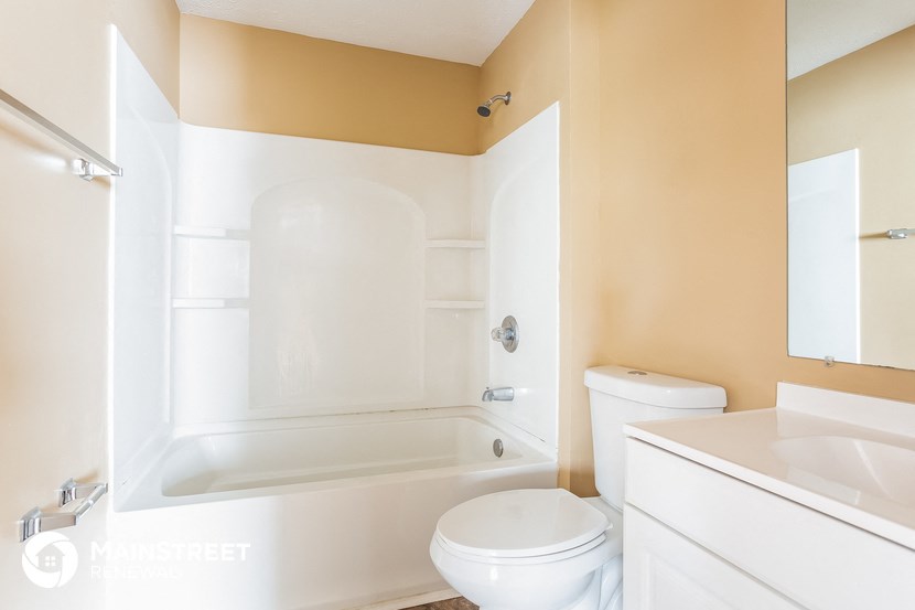 a bathroom with a toilet and a tub and a sink