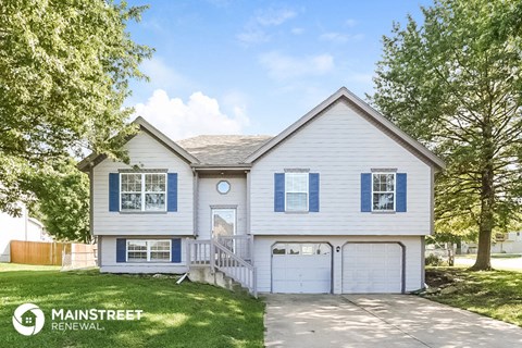 a white house with blue shutters and a driveway