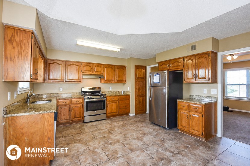 a kitchen with wooden cabinets and stainless steel appliances